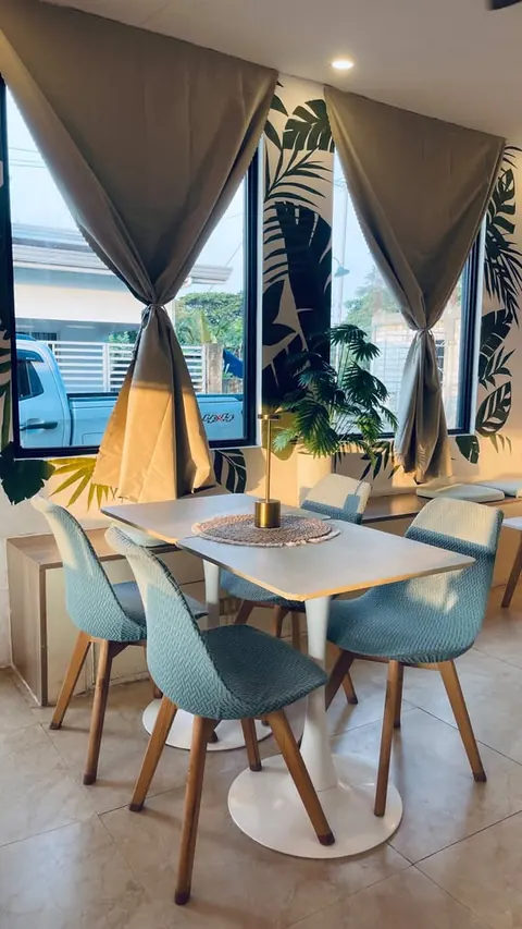 Afternoon light through tied-back curtains onto a four-seat table