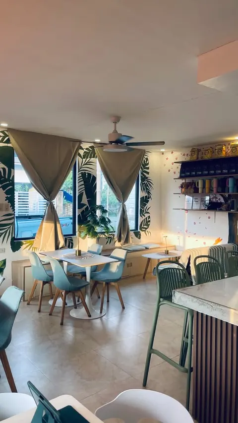 The dining room from the counter: window tables, ceiling fan and bar stools