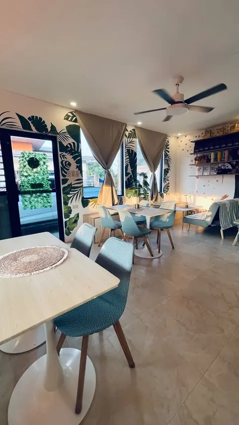 The dining room seen from the entrance, with the leafy door and palm murals