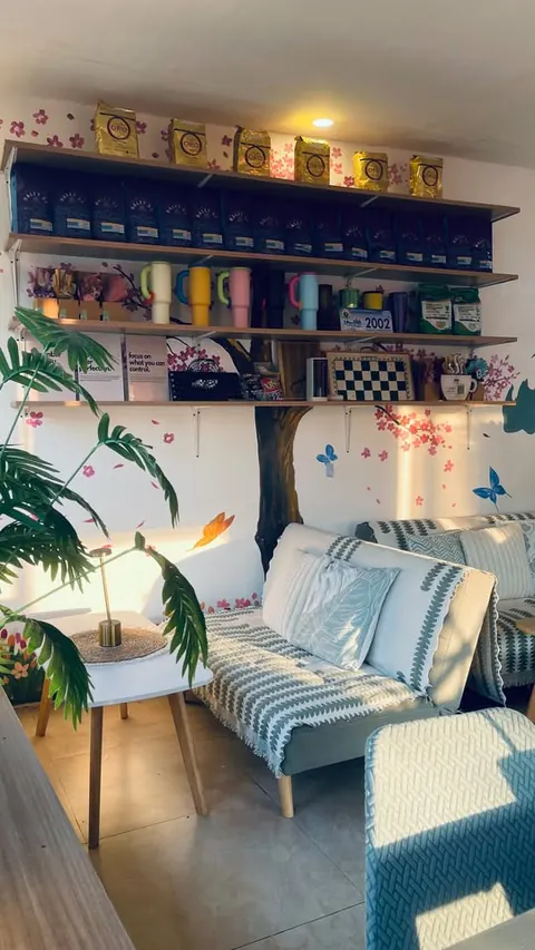 A sofa with a knit throw under the cherry blossom shelves