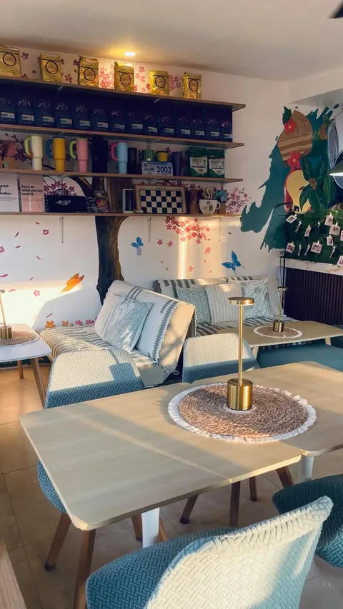 Sunlit tables with woven placemats and gold lamps in front of the sofas