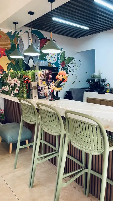 Green bar stools along the marble counter, pendant lamps and the espresso machine