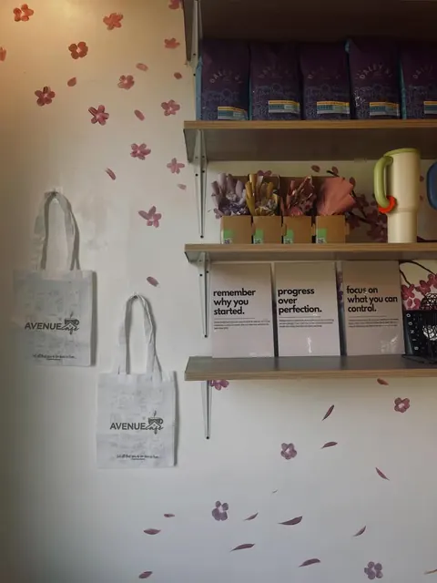 A’venue Café tote bags on the wall beside framed quotes and coffee bags