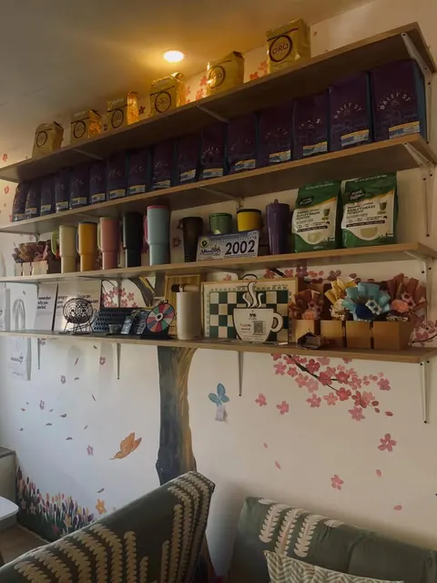 Shelves of Daley St coffee bags, A’venue tumblers and paper flower bouquets