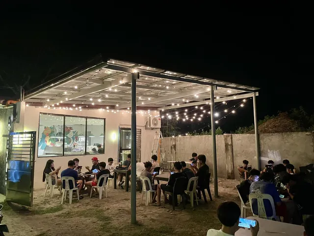 Guests at tables in the alfresco area at night under string lights