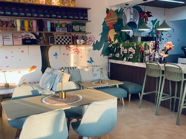 The lounge with sofas and wood tables beside the counter and its green bar stools