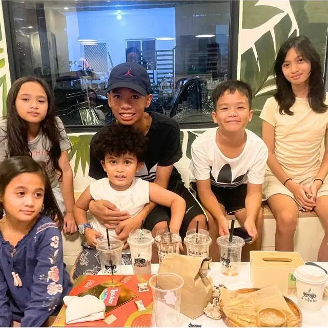 Kids and family sharing drinks and snacks at a table